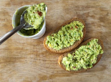 İki sandviç ve iki çay kaşığı smal ile kesme tahtasının üst görüntüsü