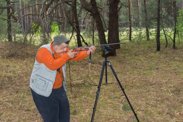 Caçador Sênior Aponta Rifle Floresta Apoiada Tripé — Fotografia de Stock