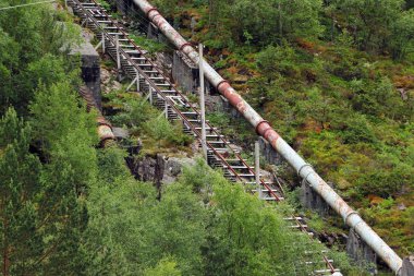 Florli, Norway - June 12, 2018: Old Florli Hydroelectric Power Station at Lysefjord, built in 1918. It has two water penstocks with a cabled railway and a wooden stairway with 4444 steps. clipart