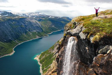 Kadın Kolları yayılır ve göl Ringedalsvatnet Trolltunga, Norveç'e yolda görünüyor.