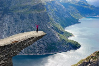 Bir kadın durumda Trolltunga (Troll dil), göl Ringedalsvatnet yukarıda cliff, popüler bir turizm, Norveç'Hordaland.