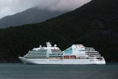 Aenes, Norveç - 19 Haziran 2018: Mv Seabourn Quest, Maurangsfjorden bir lüks cruise gemisiyle yakınındaki Furebergsfossen şelale Kvinnherad, Norveç.