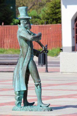 Szczebrzeszyn, Poland - May 2, 2018: Monument depicting a cricket playing violin refers to famous Polish tongue twister. The name Szczebrzeszyn is very difficult to pronounce for non-native speakers. clipart