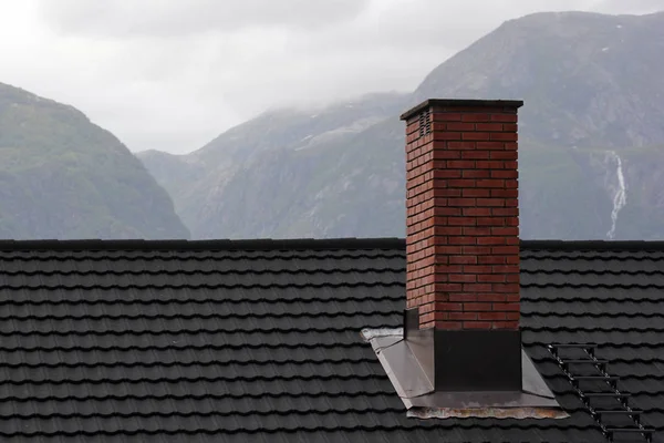 Chimenea en un techo en una zona de montaña durante el clima inclemente — Foto de Stock