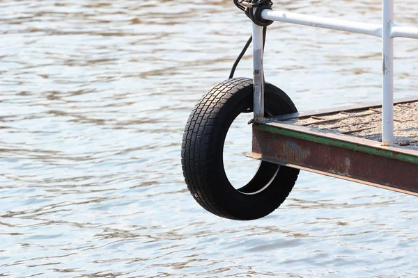 Neumático de goma viejo como un guardabarros en un muelle — Foto de Stock