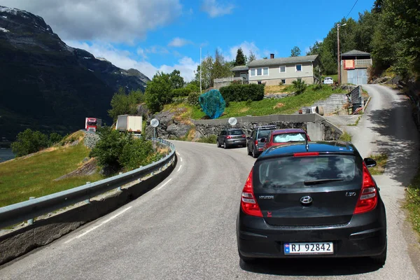 Stau auf einer schmalen Küstenstraße. Autos warten darauf, dass die Lastwagen auf einer Straße am Hardanger-Fjord aneinander vorbeifahren. — Stockfoto