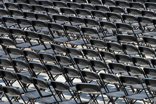 Multiple chairs outdoor, many black chair backs