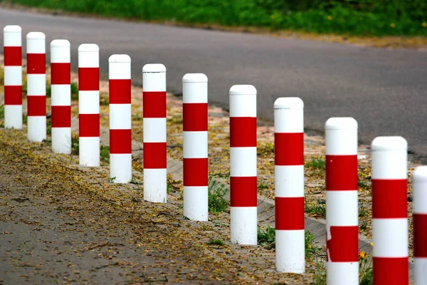 Puestos de seguridad rayados en rojo y blanco en carretera — Foto de Stock