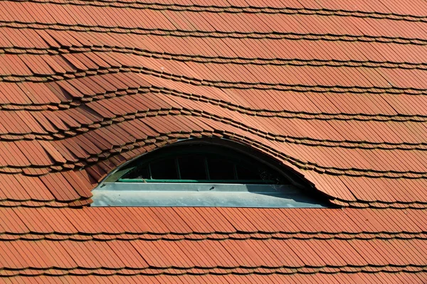 Szczegółowy widok tradycyjnego czerwonego dachu, z małymi oknami o podobnych oczach — Zdjęcie stockowe
