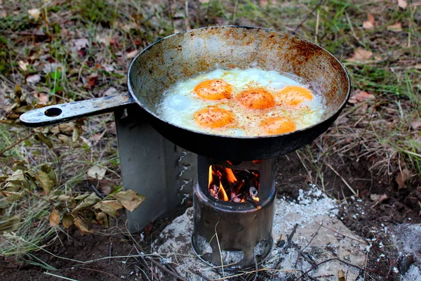 Ovos fritos no pequeno fogão a lenha portátil — Fotografia de Stock
