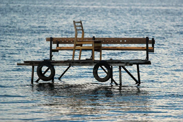 Hölzerne Fischerplattform im Wasser, mit Reifenschutzblechen und Stuhl — Stockfoto