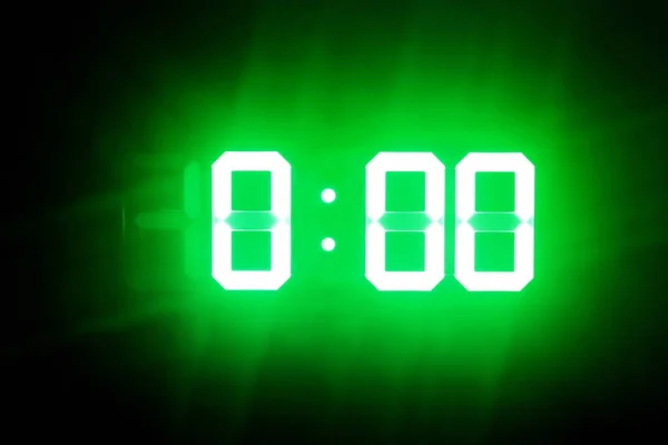 Karanlıkta yeşil parlayan rakamlar 0:00'da. Gece yarısı saati.