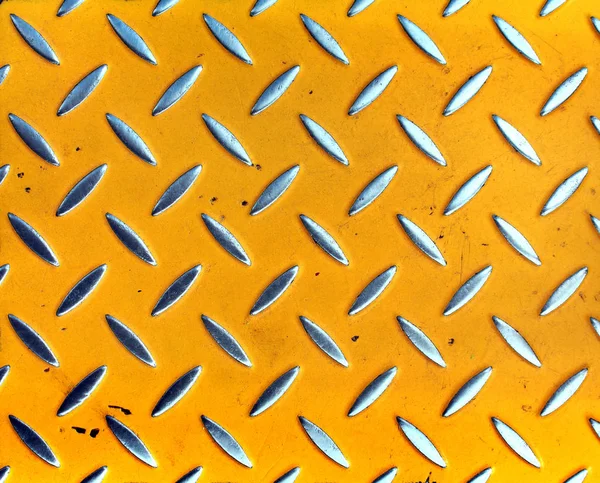 Sarı boyalı metal zeminde yıpranmış güvenlik tümsekleri — Stok fotoğraf
