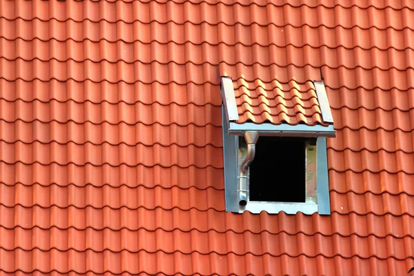 橙色瓷砖屋顶的阁楼窗口 — 图库照片