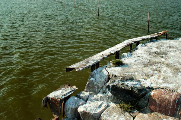 Rdzewieje żelazne ramy starego betonowego molo — Zdjęcie stockowe