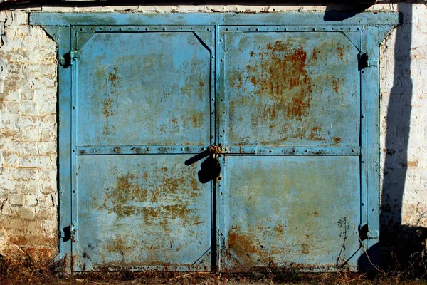 De vieilles portes de garage en métal. Peinture écaillée et rouille sur les portes du bâtiment abandonné . — Photo