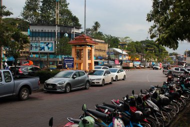 Surat Thani, Tayland - 9 Aralık 2019: Arabalar merkez tren istasyonunun yanındaki küçük meydanda saat kulesinin yanına park edildi. 