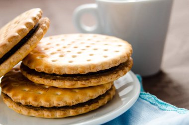 Bir fincan kahve ve çikolata dolgulu bisküvi ile İtalyan kahvaltısı