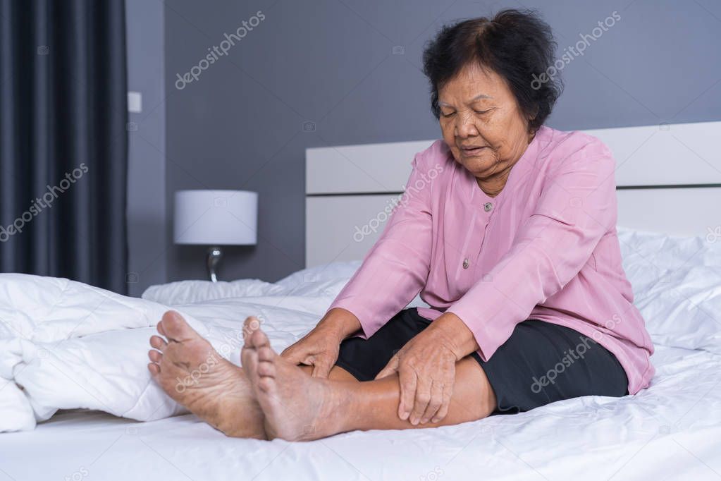 senior woman with leg pain in a bed