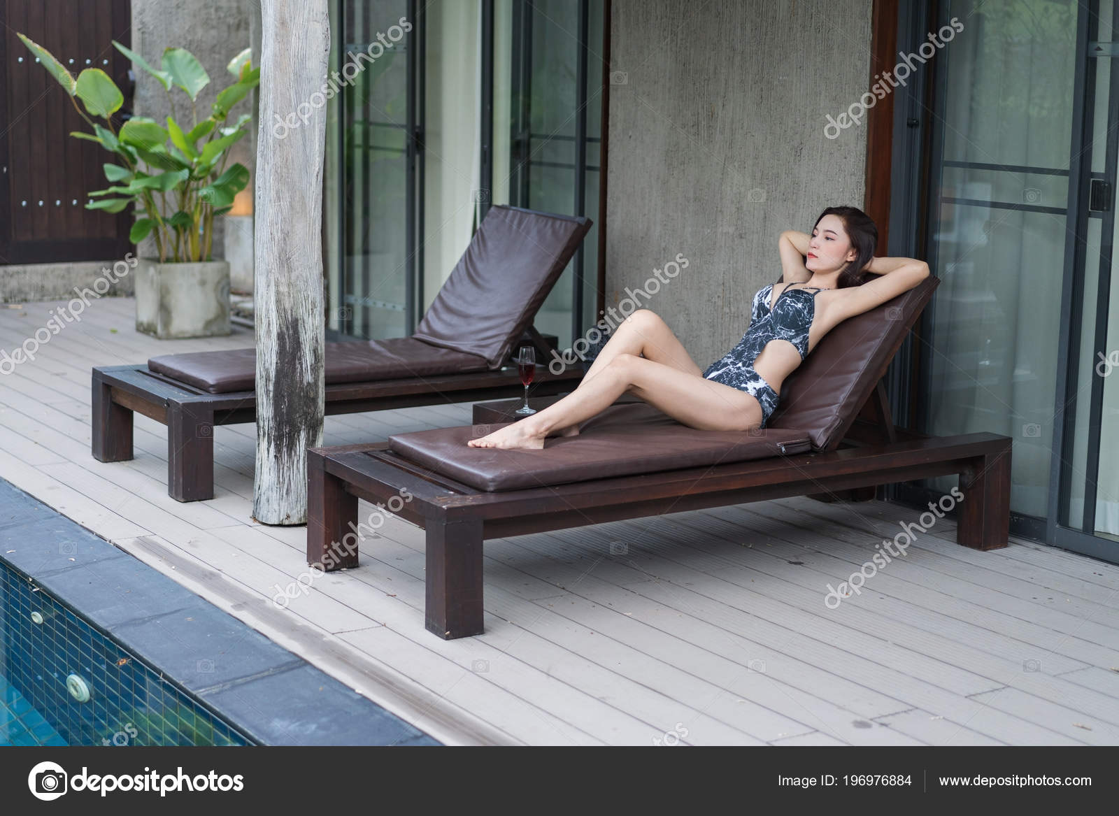 young woman relaxing on a chair at swimming pool 196976884