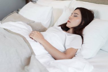Yatak odasında bir yatakta uyuyan kadın