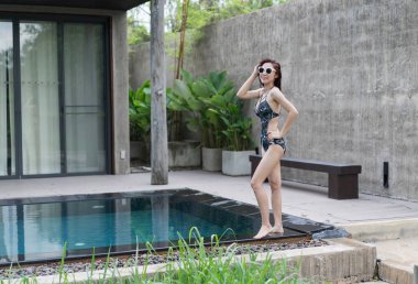 Yüzme havuzunda duran genç güzel kadın