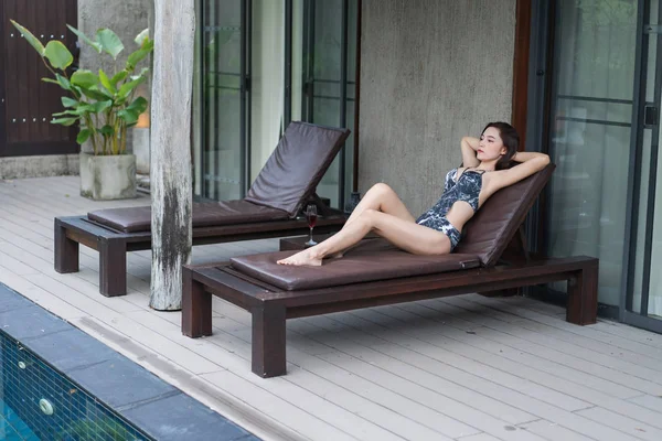 Genç kadın bir sandalyede Yüzme Havuzu, rahatlatıcı