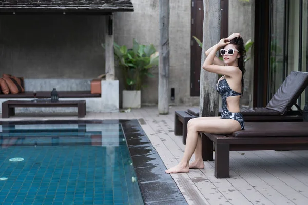 Genç kadın bir sandalyede Yüzme Havuzu, rahatlatıcı