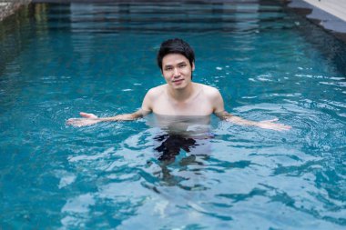 Yüzme havuzunda oynayan genç adam