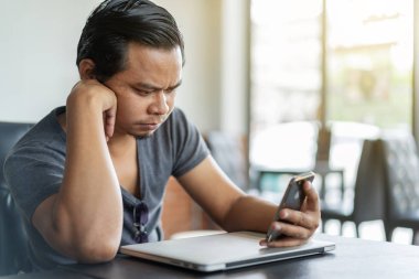 Genç adam bir kafede Smartphone kullanarak vurguladı