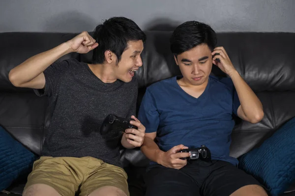 Dos Jóvenes Jugando Videojuegos Mientras Están Sentados Sofá Ganar Perder — Foto de Stock
