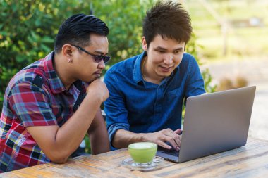 iki kullanan adam ve bir dizüstü bilgisayar üzerinde çalışan