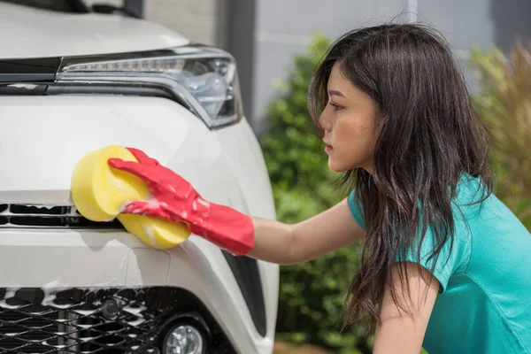 車を洗うスポンジを保持している女性 — ストック写真