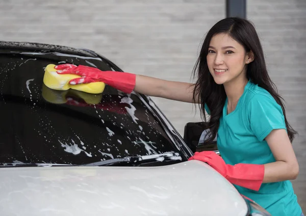 女性洗濯のフロント ガラスに洗車スポンジと — ストック写真