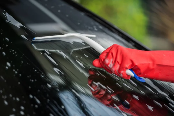 車のフロント ガラスを洗浄するスキージを使用して手 — ストック写真