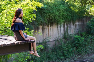 ahşap iskelesi kenarında oturan kadın