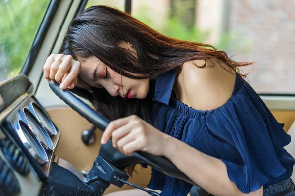 young woman sleeps in the vintage car
