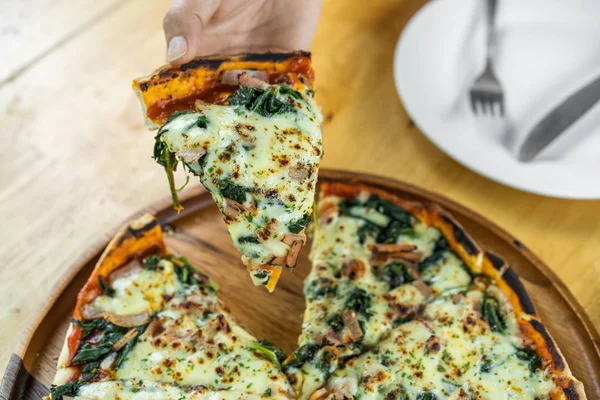 Hand Grabbing Piece Spinach Goat Cheese Pizza Wooden Table — Stock Photo, Image