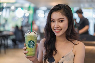 Nakhon Ratchasima, Tayland - 28 Eylül 2018: Starbucks coffee shop Teminal 21 Alışveriş merkezinde Nakhon Ratchasima, Tayland içinde yeşil çay frappe krema ile bardak tutan kadın