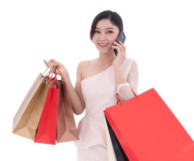 smartphone üzerinde konuşmak ve alışveriş torbaları üzerinde beyaz bir arka plan izole tutan kadın