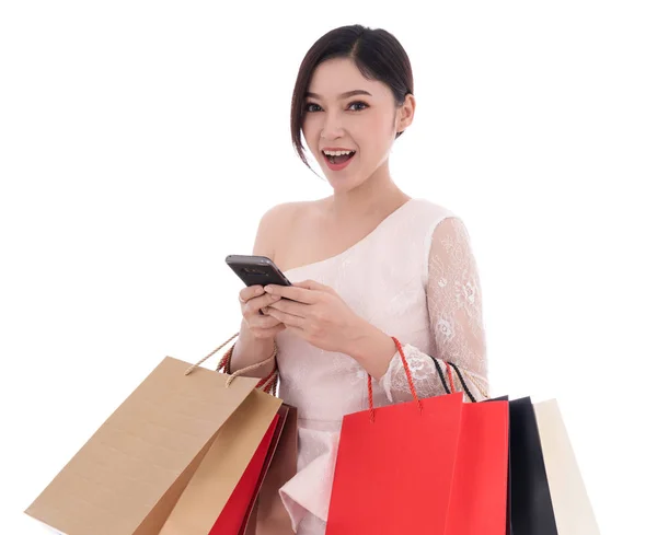 Frau Benutzt Smartphone Und Hält Einkaufstüten Isoliert Auf Weißem Hintergrund — Stockfoto