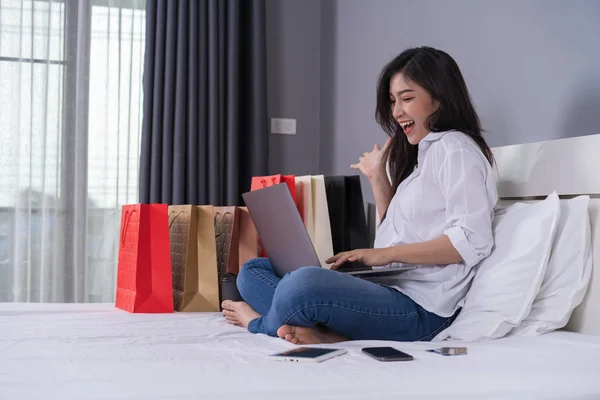 Χαρούμενη Γυναίκα Χρησιμοποιεί Φορητό Υπολογιστή Για Online Αγορές Ένα Κρεβάτι — Φωτογραφία Αρχείου