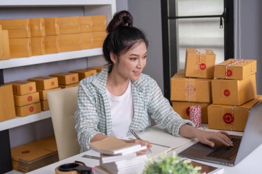 Genç kadın girişimci kontrol ve karton, KOBİ iş ile online sipariş yazma hazırlamak'dır müşterilere ev ofis