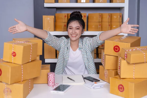 小包と成功した若い女性起業家ボックス ショッピング オンライン事業家で彼女自身の仕事で事務所 — ストック写真