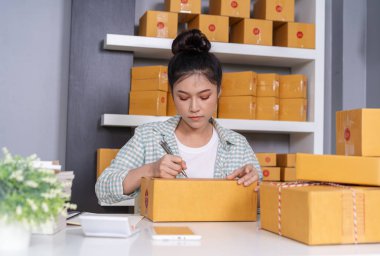 Genç kadın girişimci parsel kutusunda, online iş, yazma teslim edilmeden önce hazırlamak