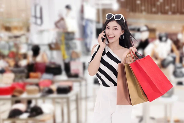 Mujer Yong Hablando Teléfono Inteligente Sosteniendo Bolsas Compra Centro Comercial —  Fotos de Stock