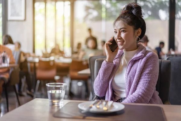 Женщина разговаривает по мобильному телефону в ресторане — стоковое фото
