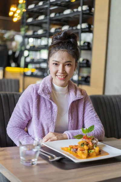 beautiful young woman with food in restaurant