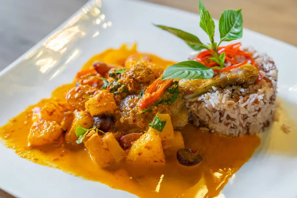 Duck confit with red curry served with brown rice on plate — Stock Photo, Image