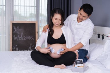 kocası ve karın hamile karısını yatakta Bebek çorap ile